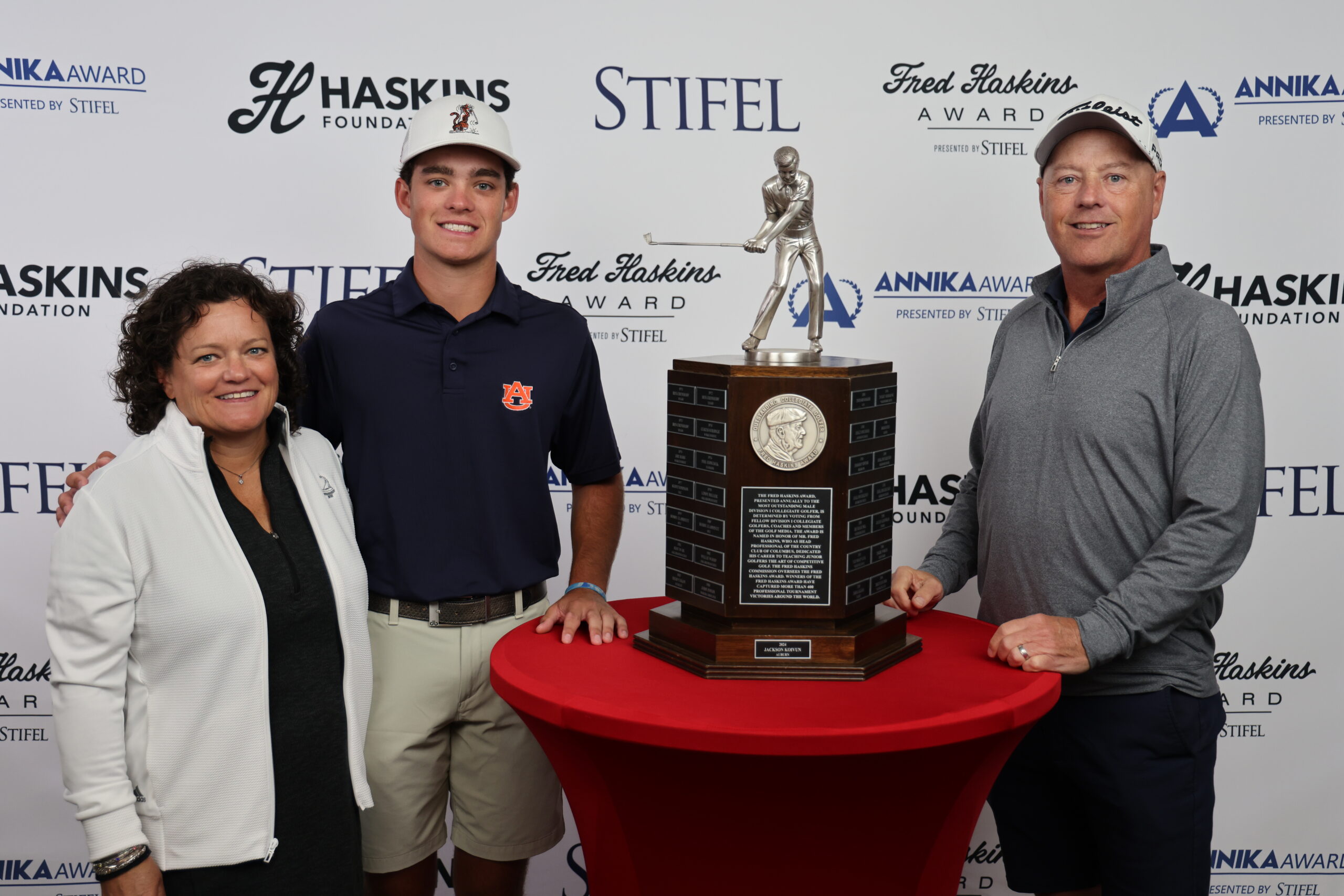 Jackson Koivun takes a photo with the Haskins Award trophy with his family.