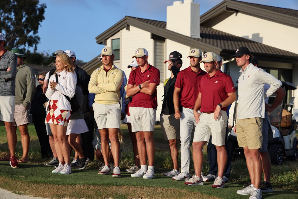 Florida State's men's golf team watches teammate Clanton tee off on Hole 16.