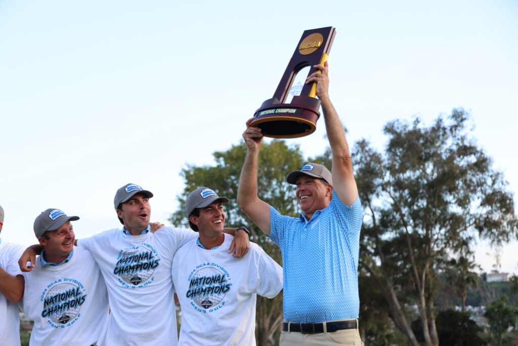 Coach Clinard raises the NCAA trophy high.