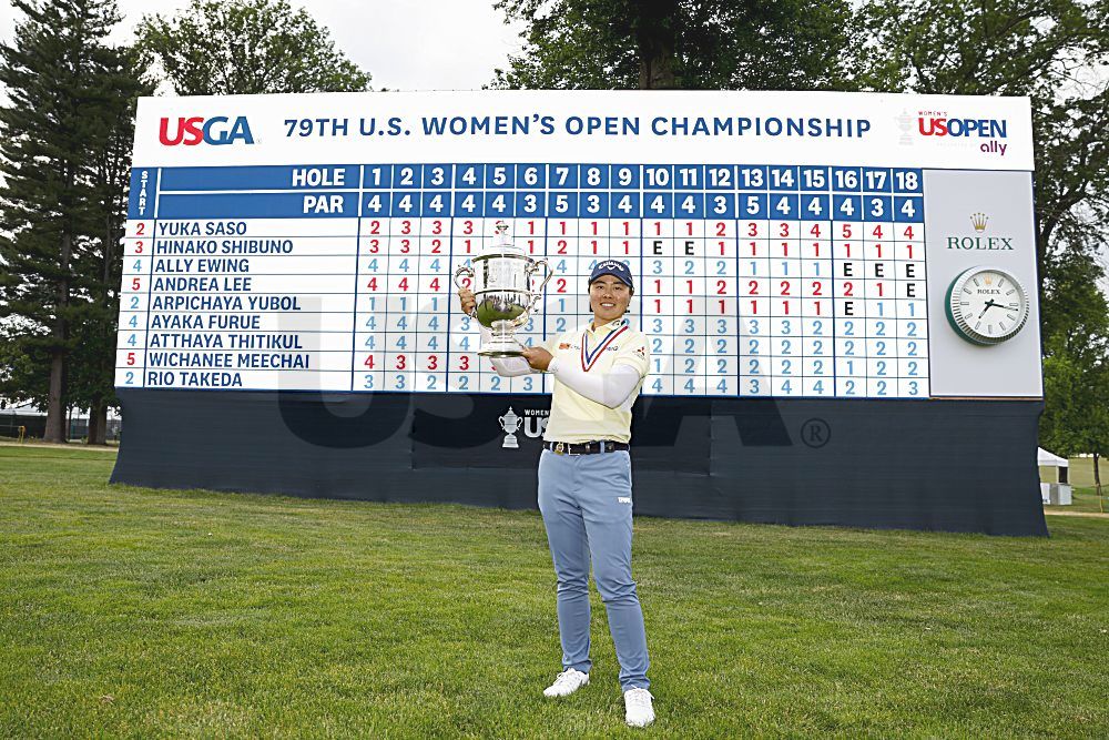 Yuka Saso holds the trophy in front of the scoreboard after she won the 2024 U.S. Women's Open Presented by Ally at Lancaster Country Club in Lancaster, Pa. on Sunday, June 2, 2024. (Chris Keane/USGA)