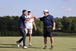 Wells Adams fist bumps first responder Gerry Murphy for sinking their 6-footer.