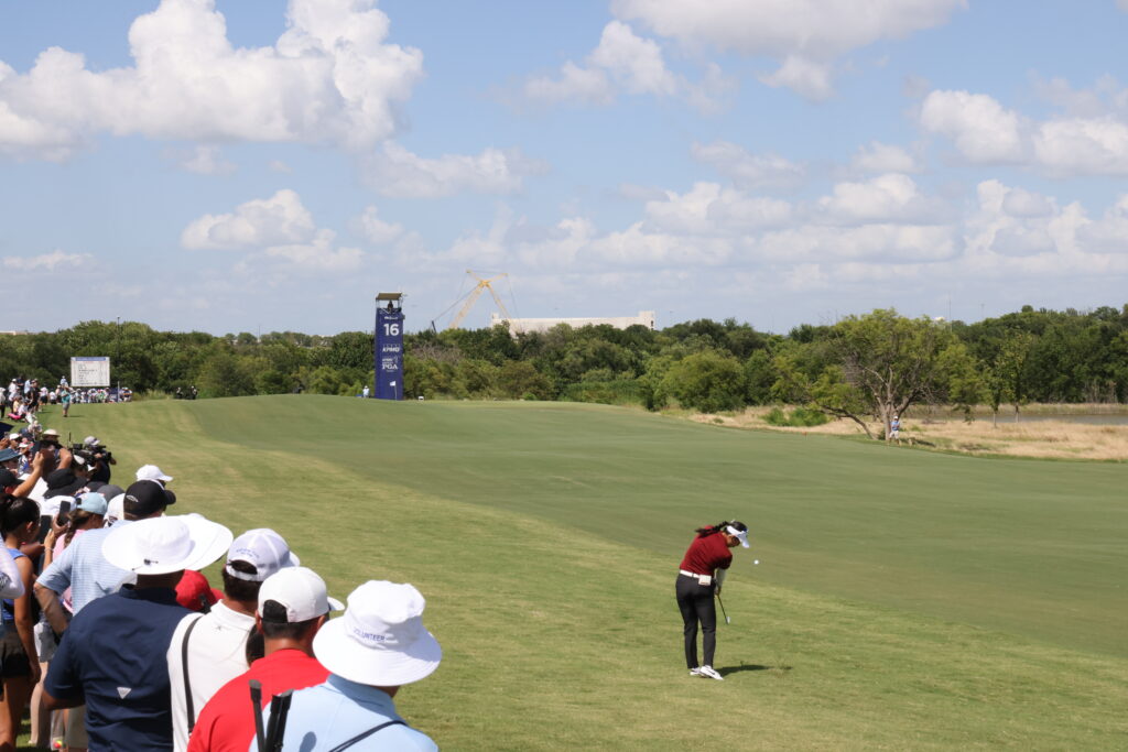 Thailand's Jeeno Thitikul hits her approach shot on hole 16 as fans look on.