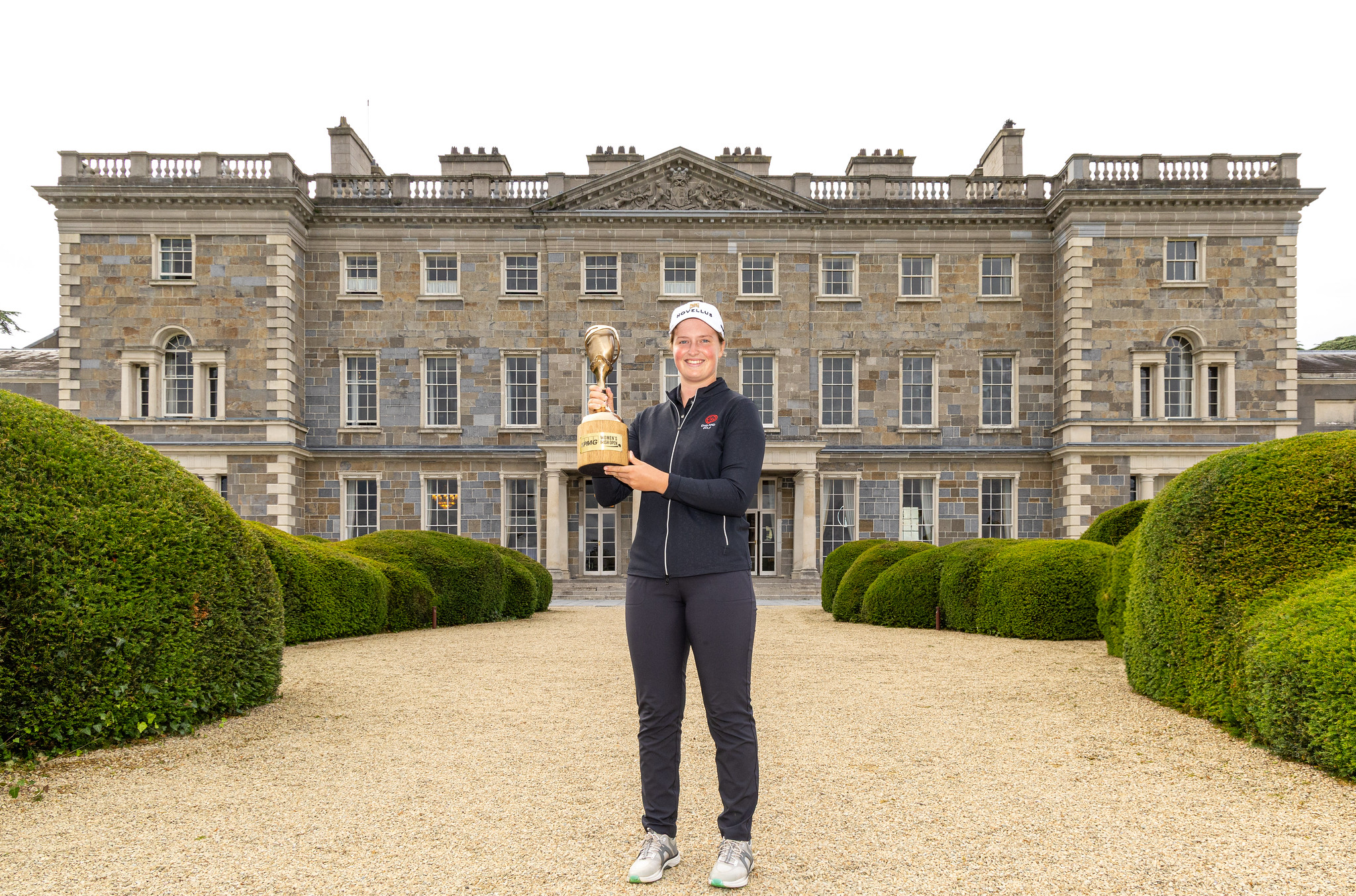 Lottie Woad of England posting with her trophy in front of the Carton House.