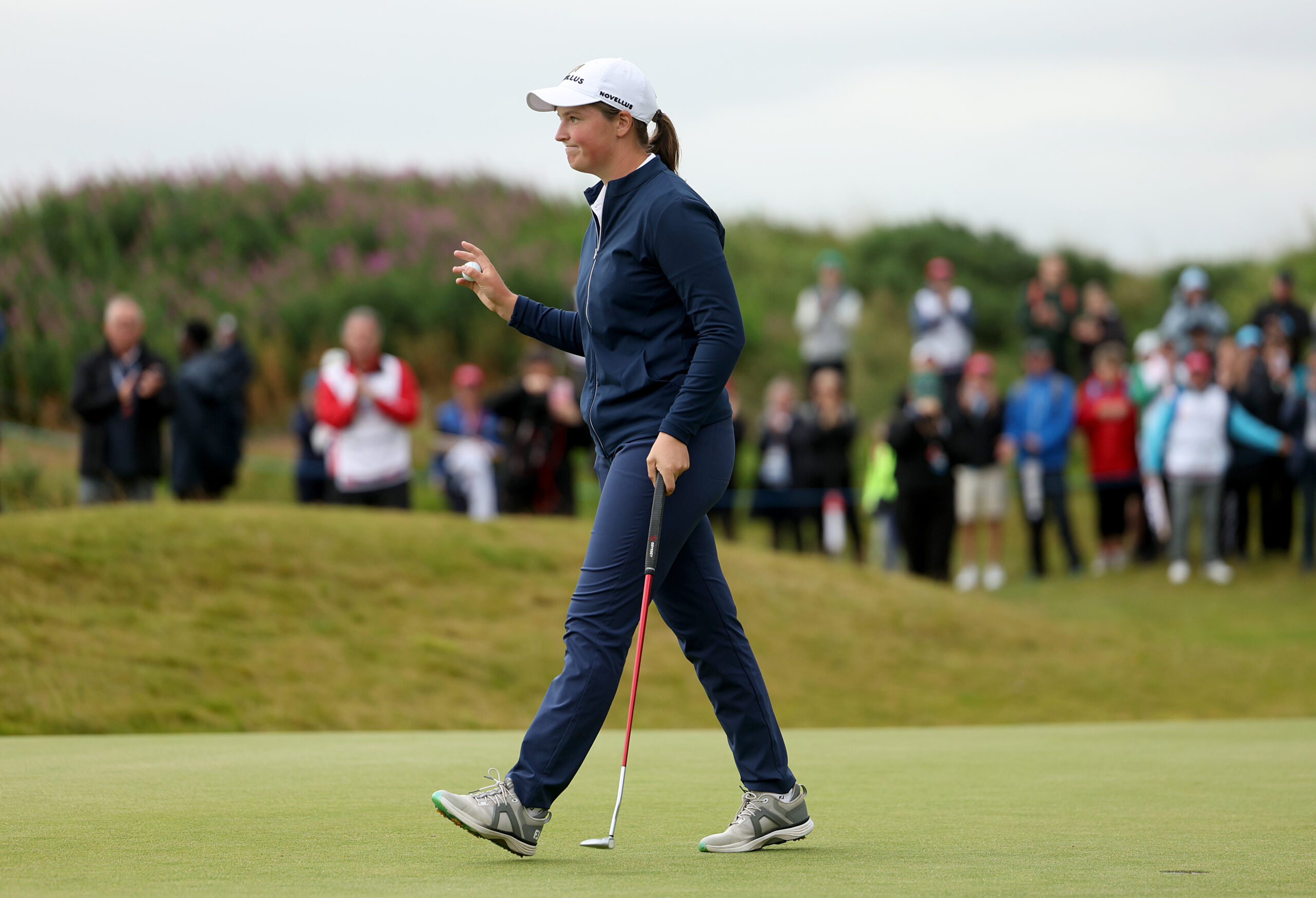 Lottie Woad of England acknowledges the crowd as she celebrates victory of the ISPS HANDA Women's Scottish Open the 18th green following the final round.