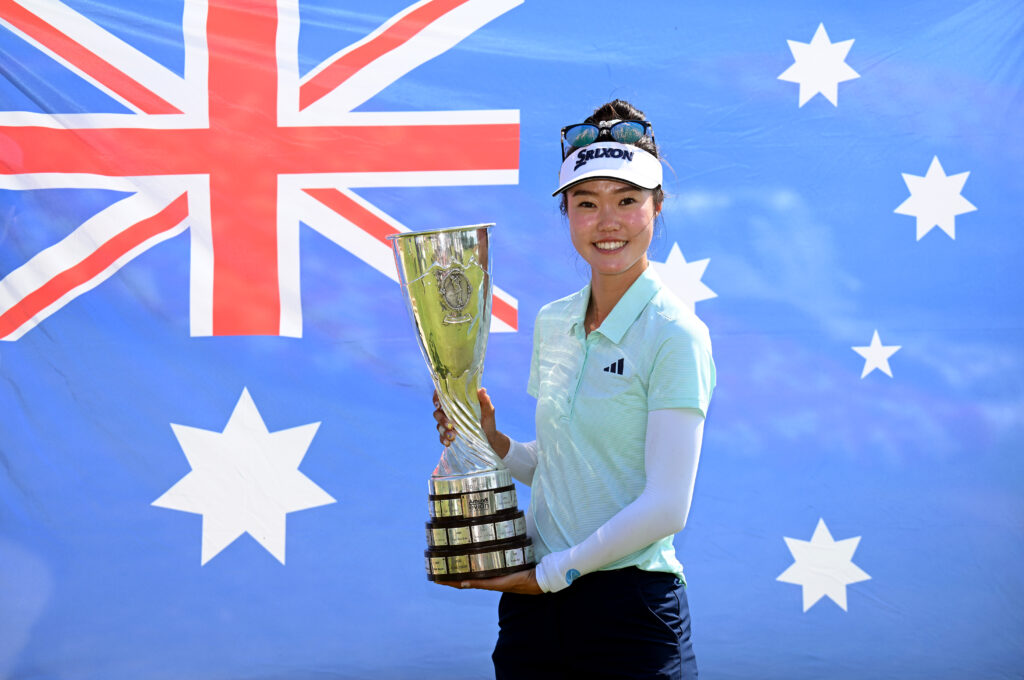 Australia's Grace Kim poses for a photograph with The Amundi Evian Championship 2025 trophy in front of the national flag of Australia following the final round of The Amundi Evian Championship.