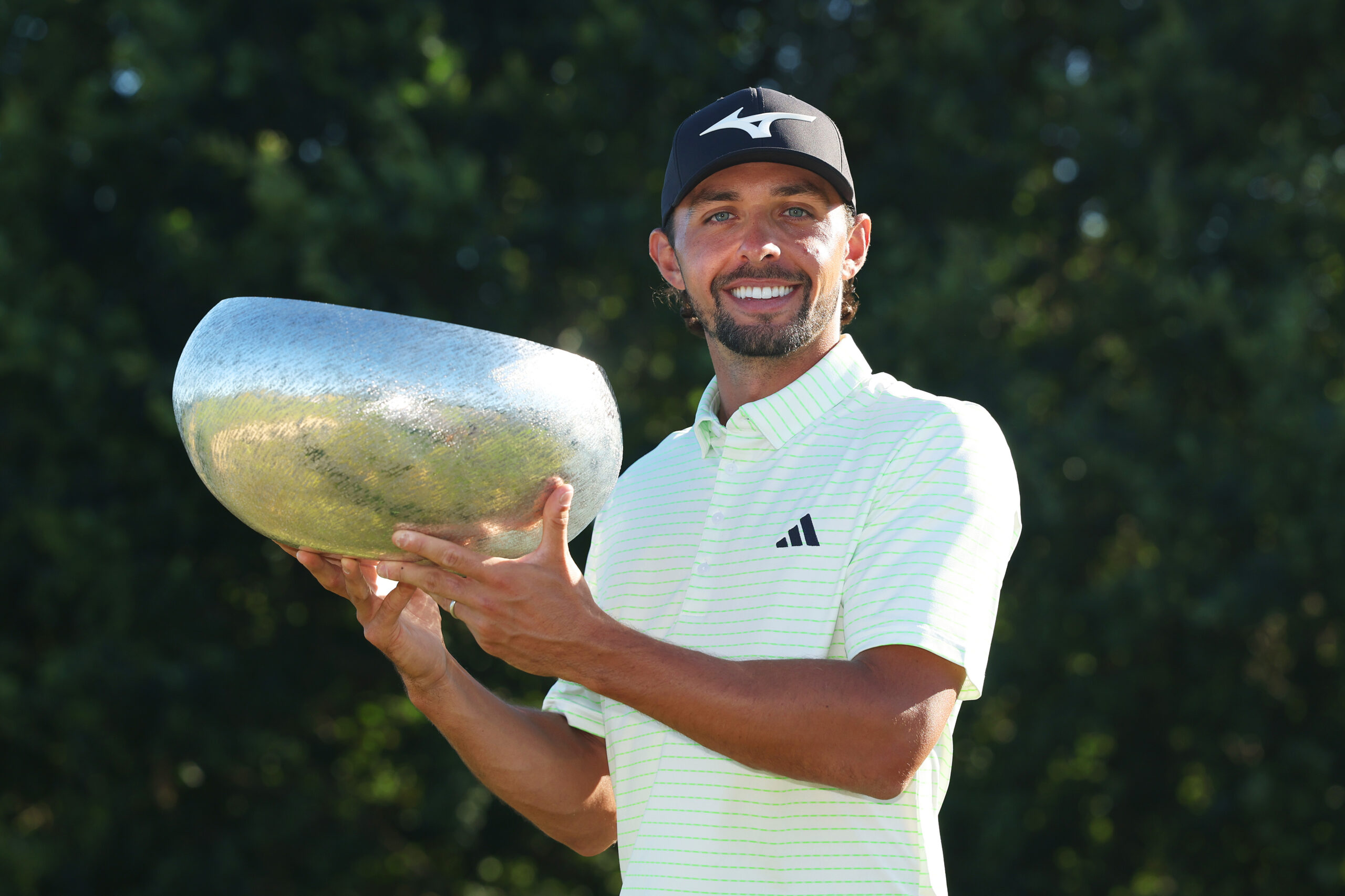 Marco Penge of England poses with the trophy on the 18th hole after winning the Danish Golf Championship.