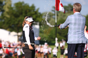 Brooke M. Henderson of Canada is sprayed with champagne on the 18th green after winning the CPKC Women's Open 2025 at Mississaugua Golf and Country Club.