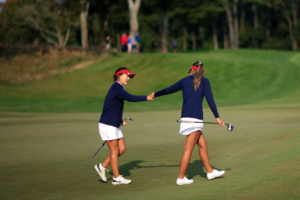 Lily Peng and Anna Fang of Team United States fist bump on the fourth hole during the first round of the 2025 Junior Ryder Cup.