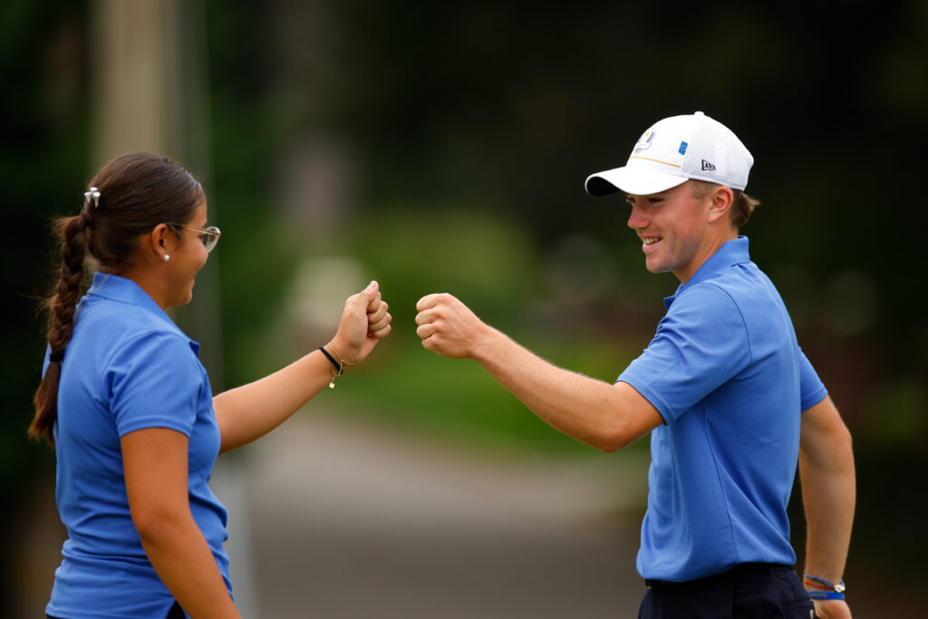 Oscar Couilleau and Louise Uma Landgraf of Team Europe interact after putting on the ninth hole during the third round of the 2025 Junior Ryder Cup.