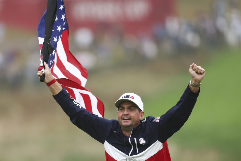 Team United States Captain Keegan Bradley waves an American flag hooked to an umbrella during the 2025 Ryder Cup Practice Round. 