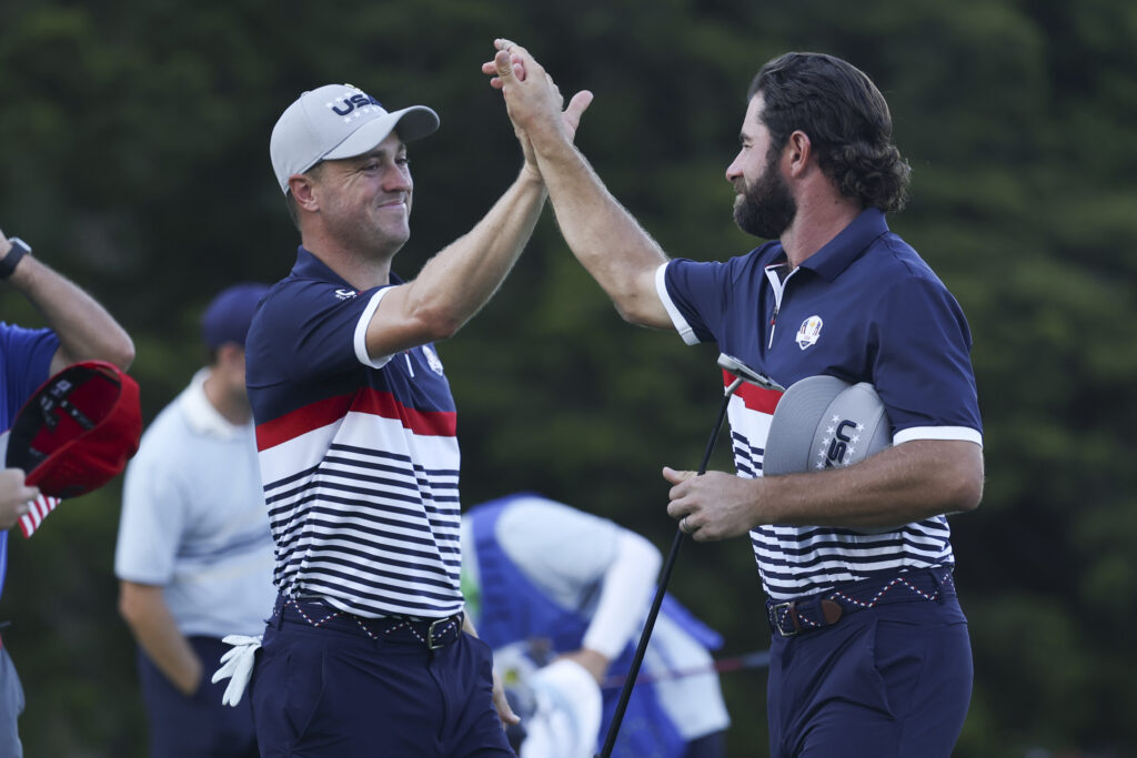 Cameron Young and Justin Thomas of Team United States high five on the 13th hole of the Black Course.