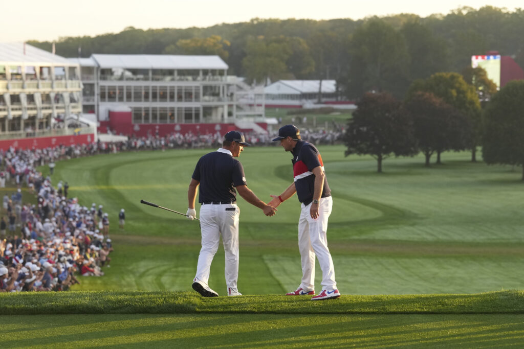 Bryson DeChambeau and Captain Keegan Bradley of Team United States high five on the first hole during the 2025 Ryder Cup.