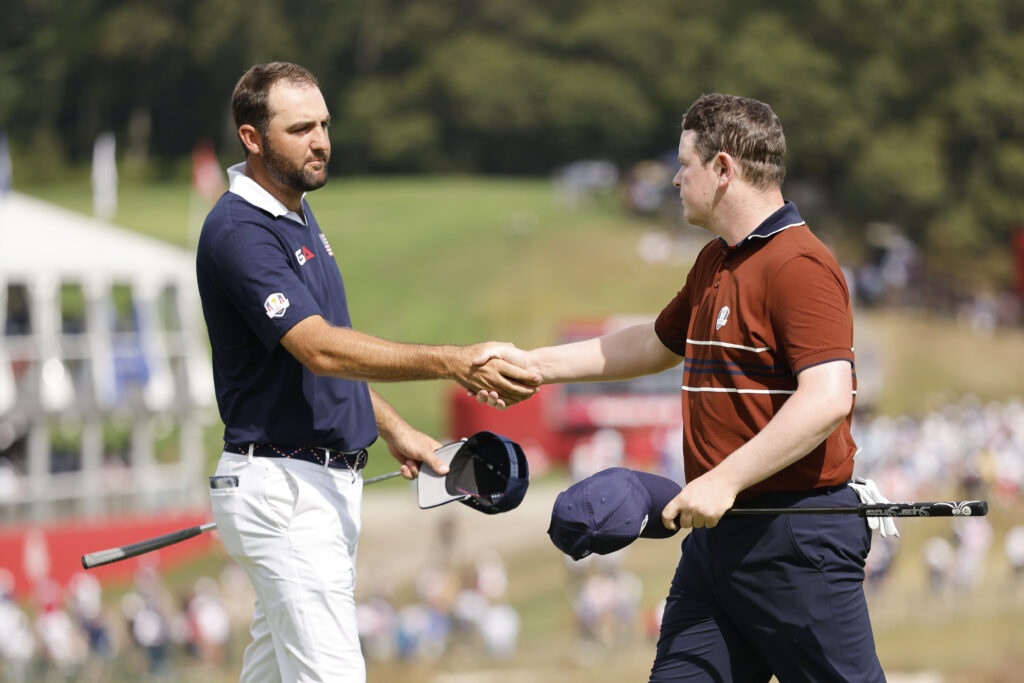 Scottie Scheffler of Team United States shakes hands with Robert MacIntyre of Team Europe on the 18th hole.
