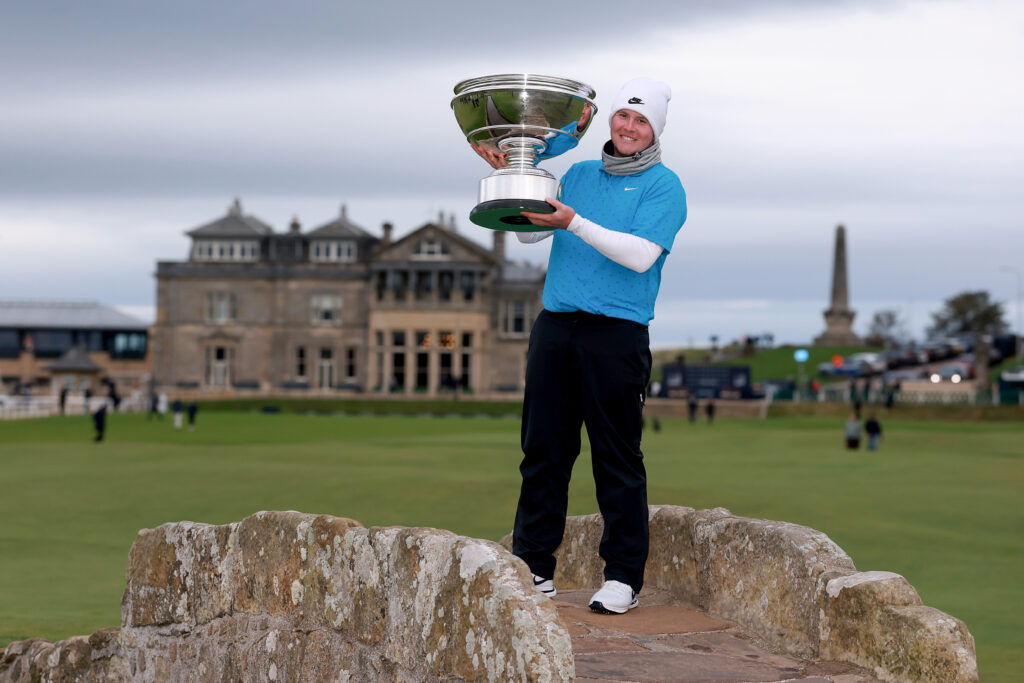 Robert MacIntyre of Scotland poses with the trophy on the Swilcan Bridge following his victory at the 2025 Alfred Dunhill Links Championship.