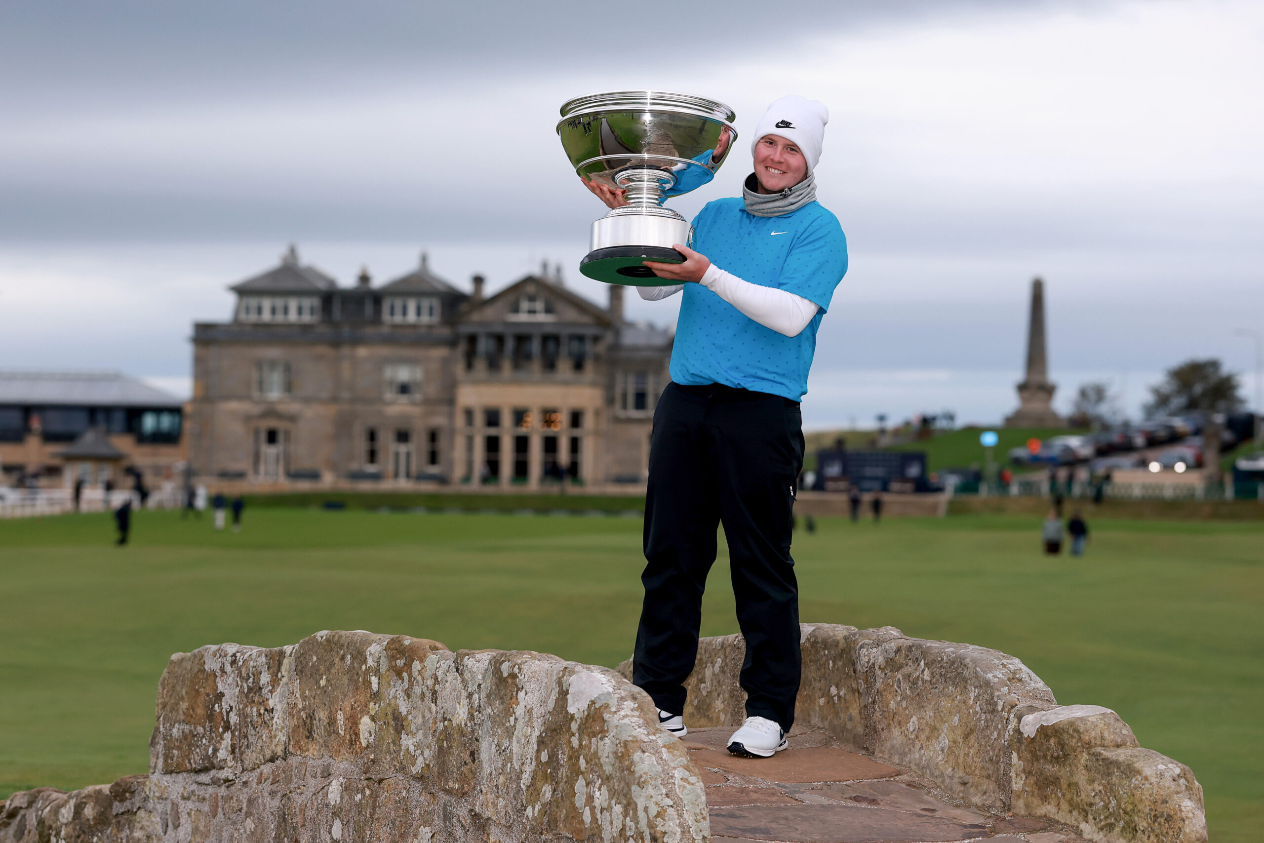 Robert MacIntyre of Scotland poses with the trophy on the Swilcan Bridge following his victory at the 2025 Alfred Dunhill Links Championship.