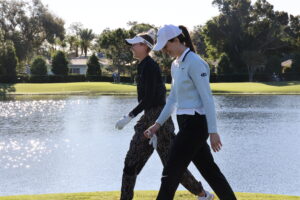Nelly Korda and Caitlin Clark walk from the tee at Pelican Golf Club.