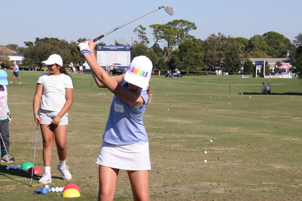 A Share My Passion participant swings on the driving range.
