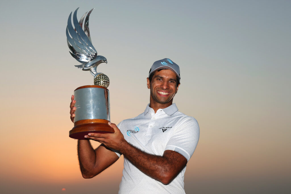 Aaron Rai of England lifts the trophy on the 18th green following victory on day four of the 2025 Abu Dhabi HSBC Championship.