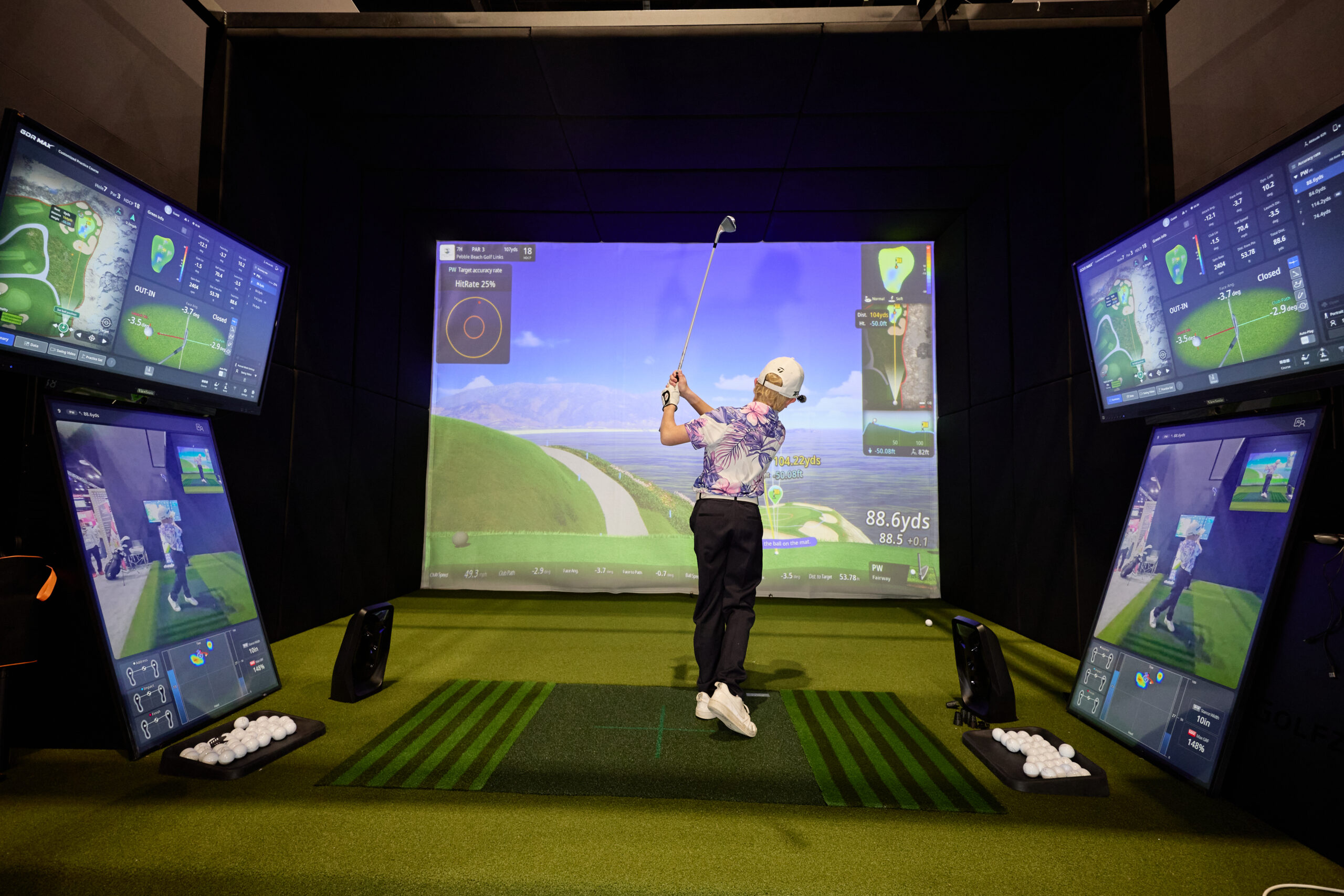 A junior golfer tries out the latest technology in a GOLFZON golf simulator at the 2026 PGA Show.