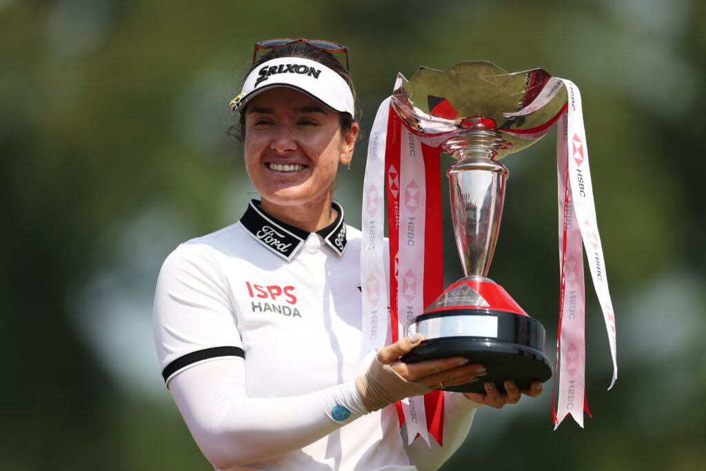 Hannah Green celebrates with the trophy on the 18th green after winning the 2026 HSBC Women's World Championship.