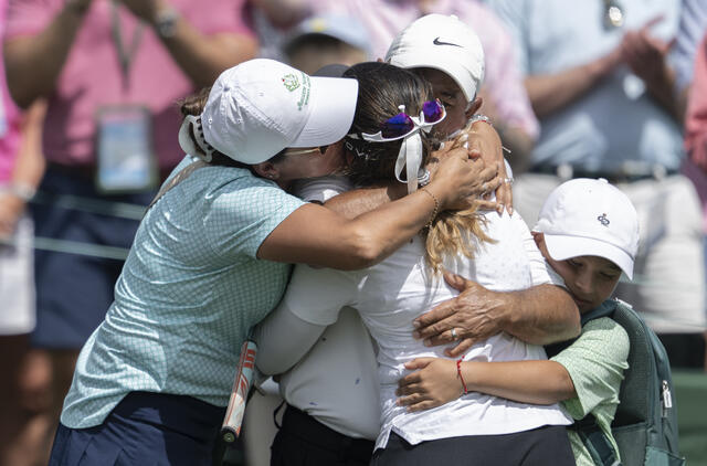 Maria Jose Marin hugs her parents after sinking her par putt on Hole 18.