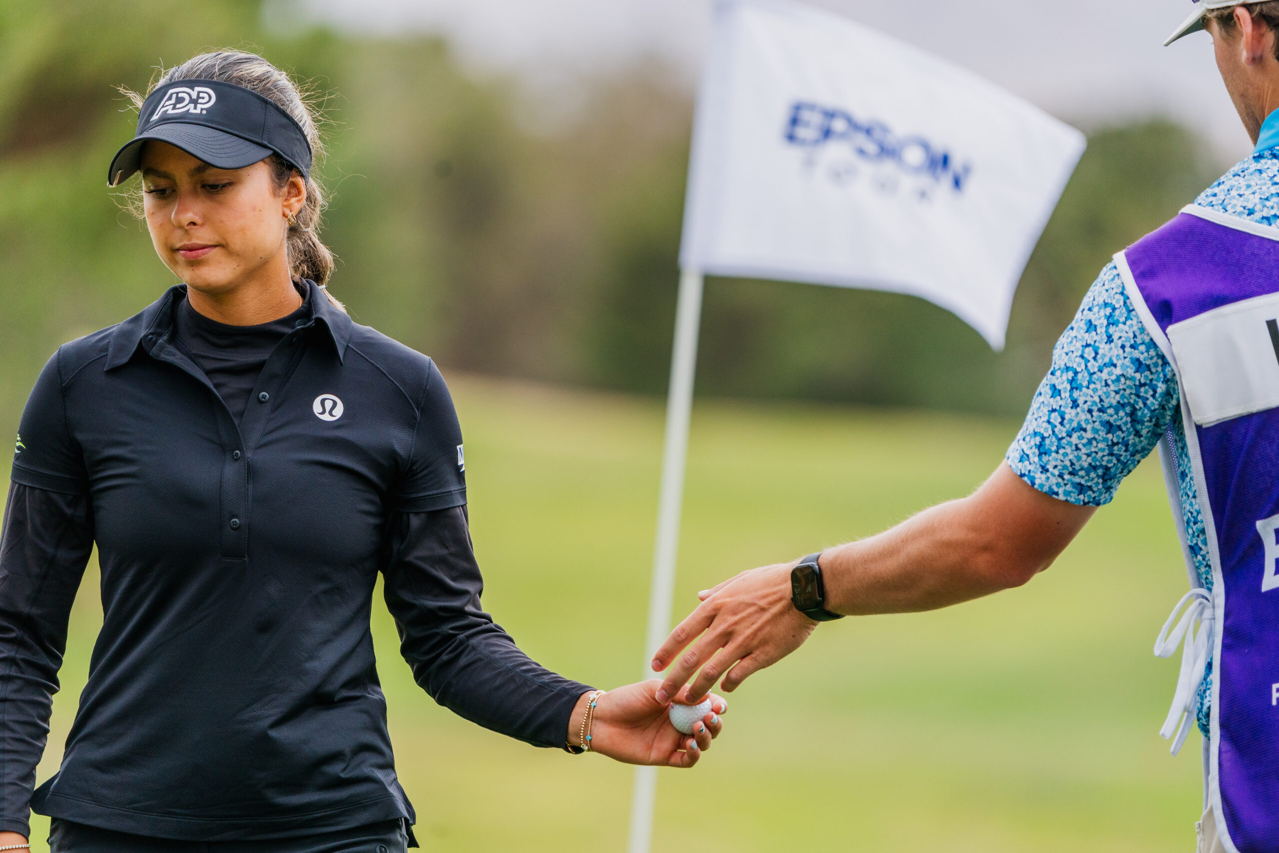 Last year's champion Yana Wilson grabs her ball to head to the next tee.