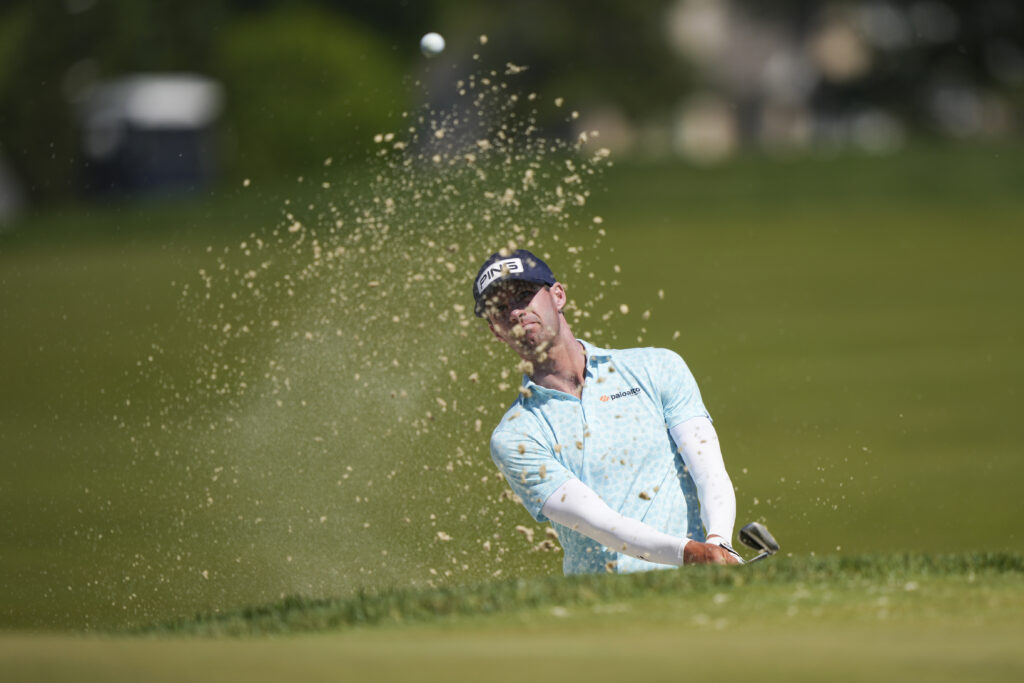 Alex Smalley hits out of the bunker on the second hole during the third round of the 2026 PGA Championship at Aronimink Golf Club.