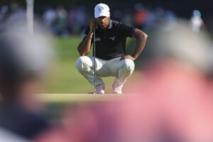Aaron Rai reads his putt on the 14th hole during the final round of the 2026 PGA Championship at Aronimink Golf Club.
