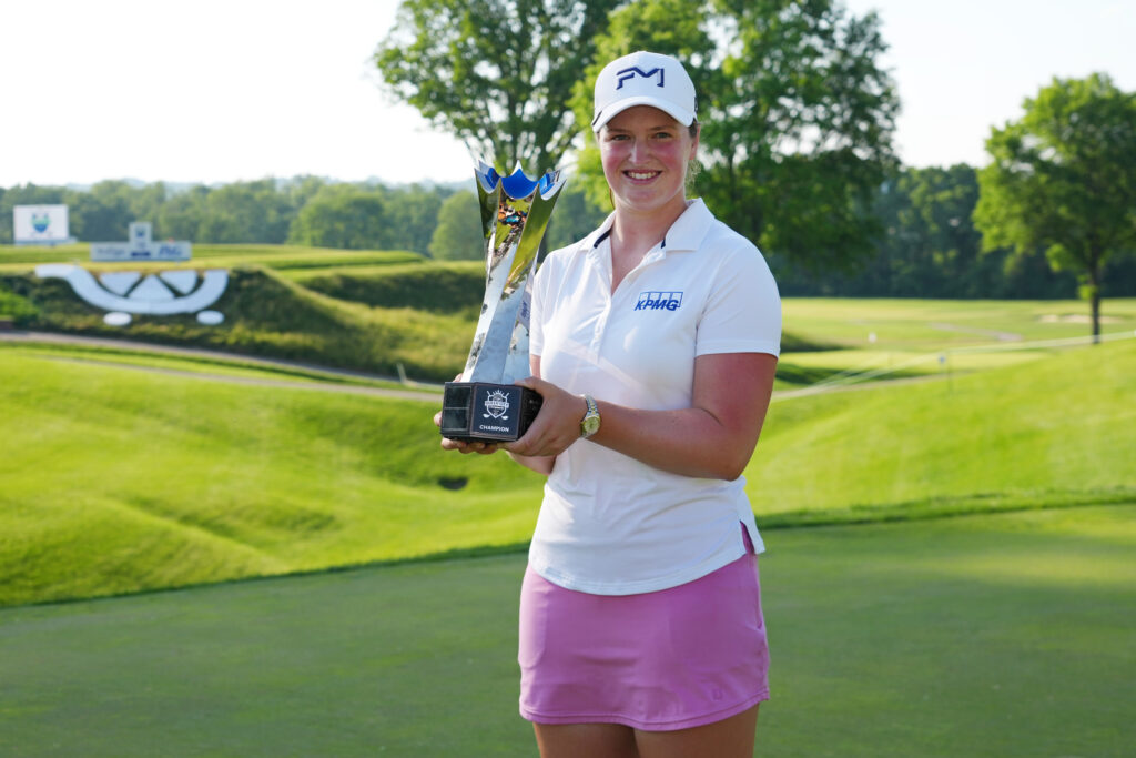 Lottie Woad poses with the trophy on the 18th green after winning the 2026 Kroger Queen City Championship presented by P&G.