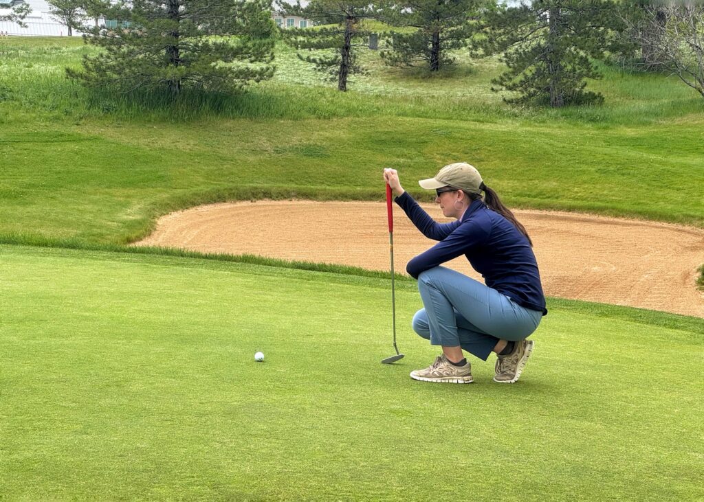 Zanny finishing her Interlocken Golf Club experience with a putt for par.